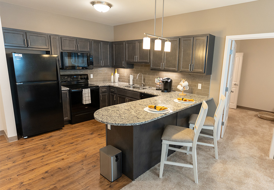 Modern kitchen with dark appliances and a bar