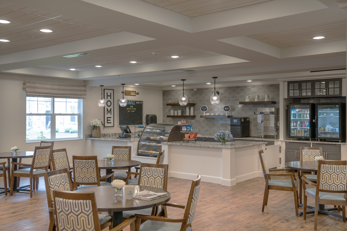 Cozy Bistro with Wooden Tables and Stylish Chairs Cozy bistro with wooden tables, stylish chairs, and a counter displaying snacks and beverages.