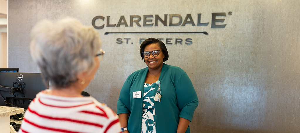 Clarendale of St peters receptionist helping senior woman