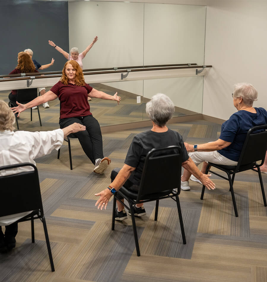 Seniors stretching during seated yoga class